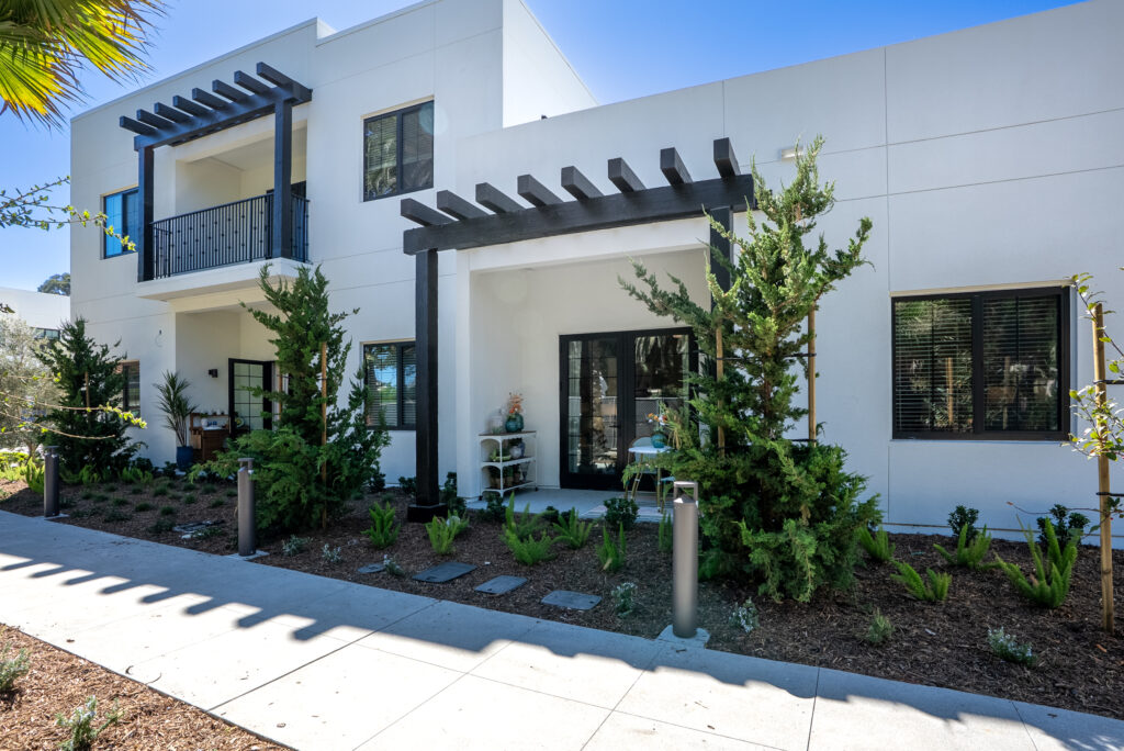 Exterior of the building showing two private terraces and a balcony above one of them, with pergola accents.