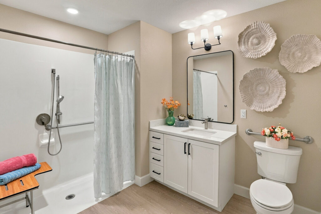 Bathroom with white vanity, mirror, zero-entry shower, and toilet.